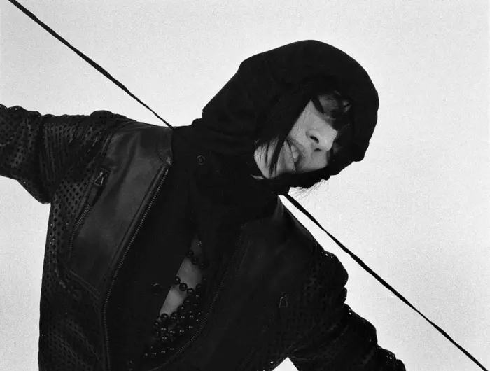 Woman in a black hoodie pulling the drawstrings